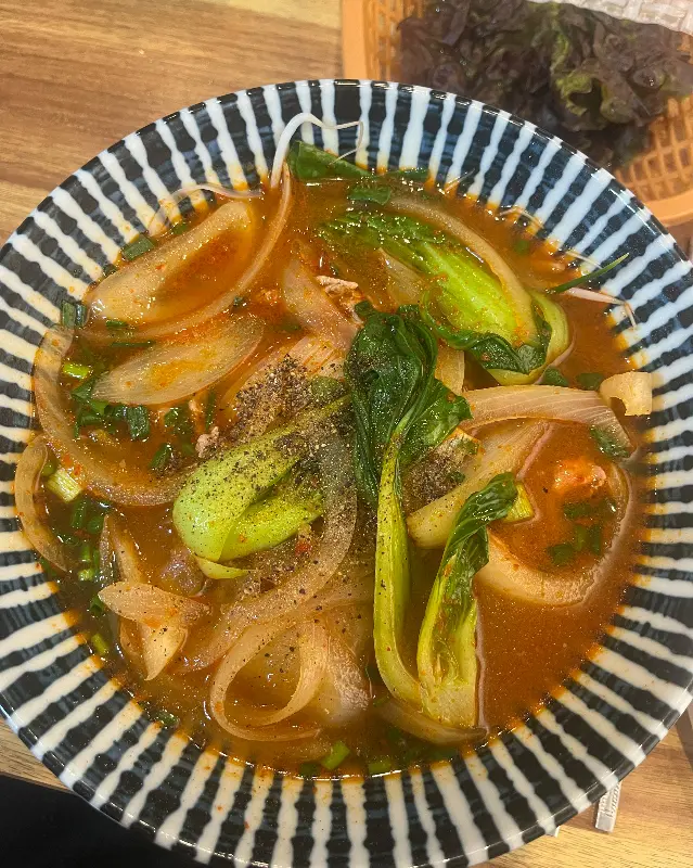 채소가 풍성하게 올려진 매운 쌀국수의 모습