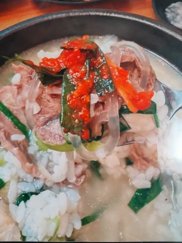곰탕에 김치를 올려 한 입 가득