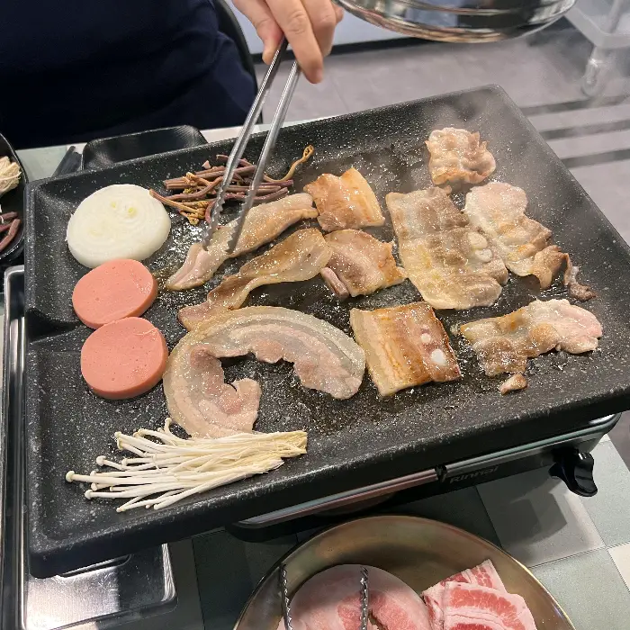 다양한 종류의 고기가 불판 위에서 익어가는 모습