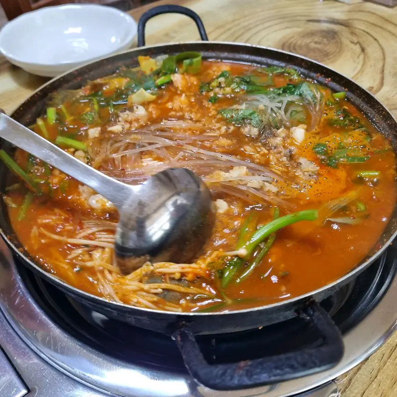 국자로 매운탕을 뜨는 모습