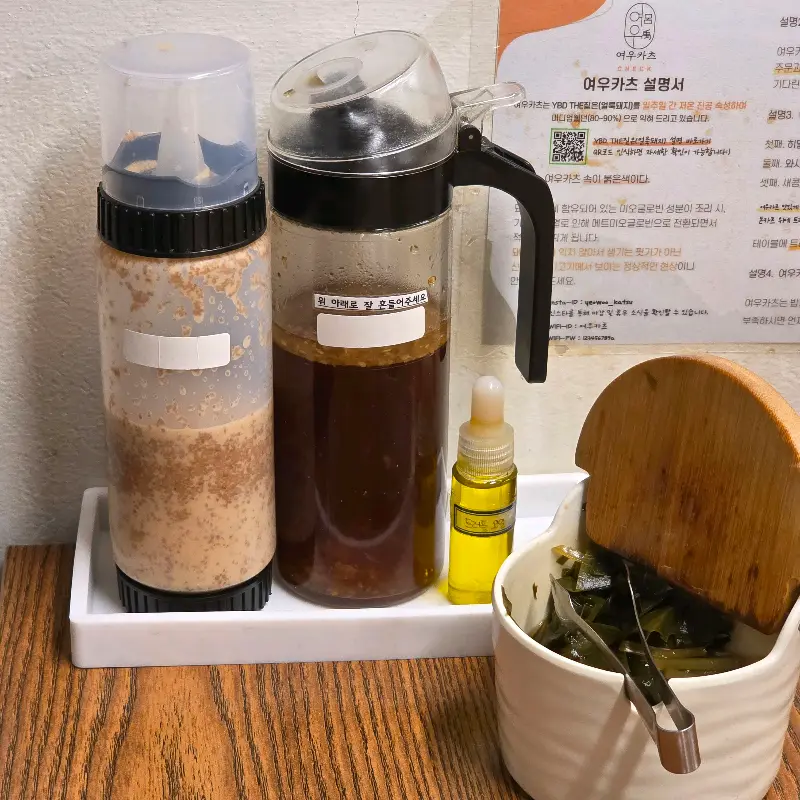 테이블 위에 놓인 돈까스 소스와 샐러드 드레싱