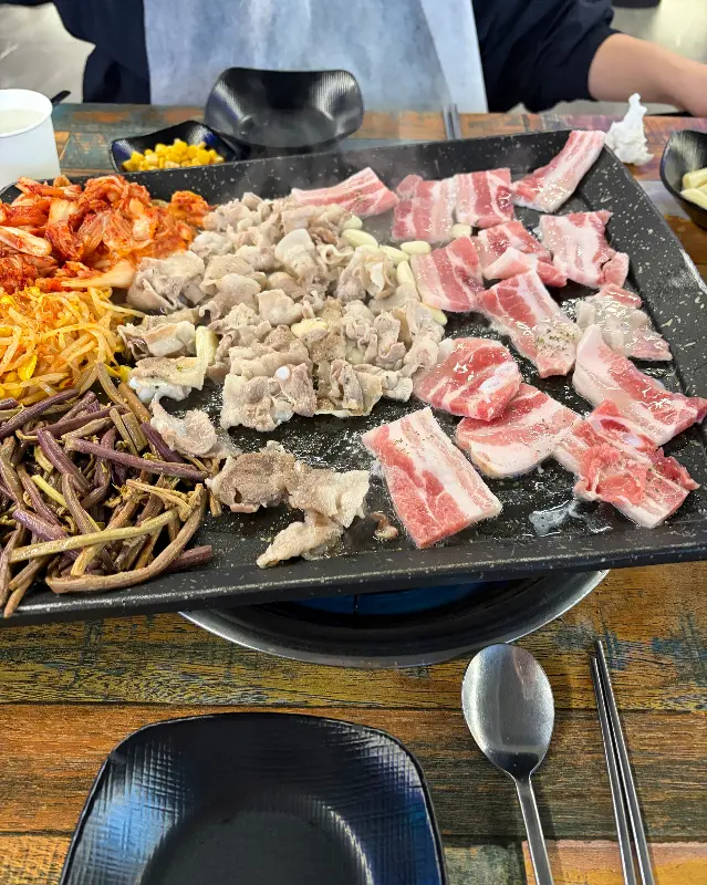 잘 구워진 대패 삼겹살과 김치, 콩나물, 고사리의 조화