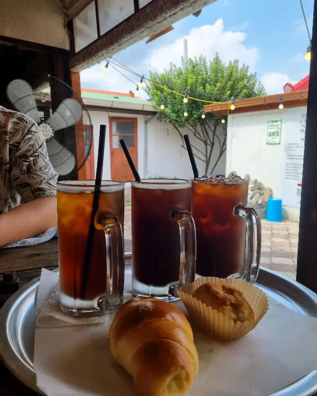 넓은 유리잔에 담긴 시원한 커피와 빵