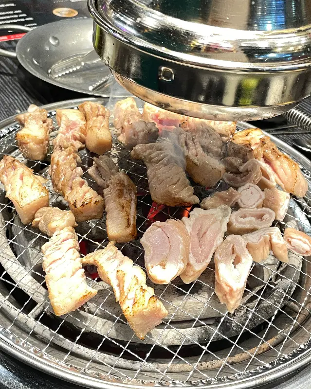 불판 가득 올려진 삼겹살과 닭목살, 그리고 막창의 조화