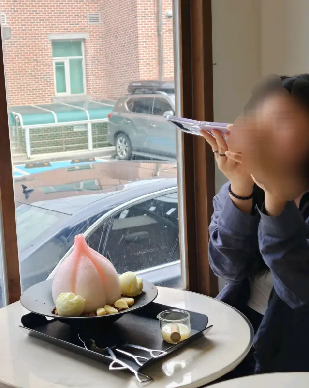 창밖 풍경을 바라보며 빙수를 즐기는 모습