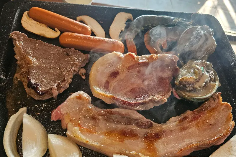 숯불 위에서 익어가는 흑돼지, 전복, 새우, 소시지