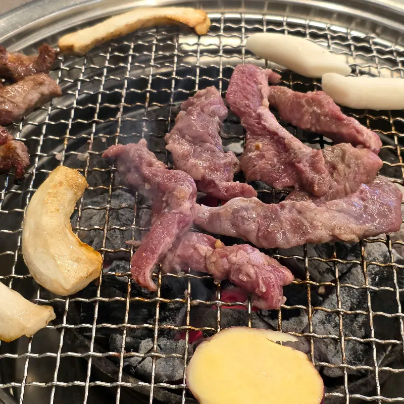 숯불 위에서 익어가는 갈매기살, 떡, 버섯