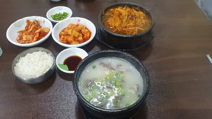 테이블에 놓인 밥, 국밥, 김치, 깍두기, 소스