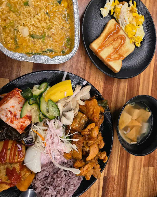 다양한 반찬과 라면, 토스트로 푸짐하게 차려진 식탁