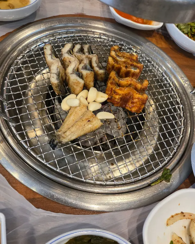 숯불 위에서 구워지는 장어와 마늘