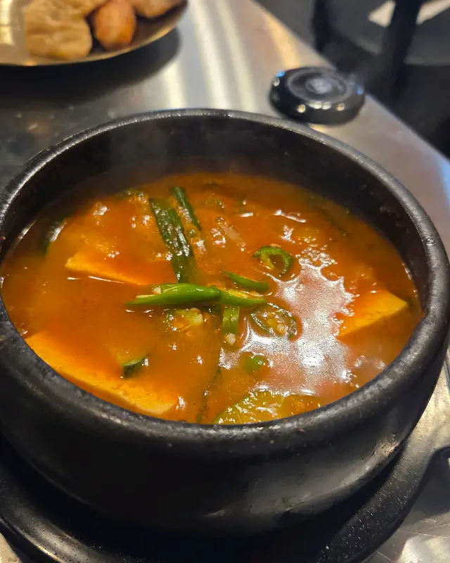 맛있게 구워진 막창 한 점을 젓가락으로 집어 올리는 모습
