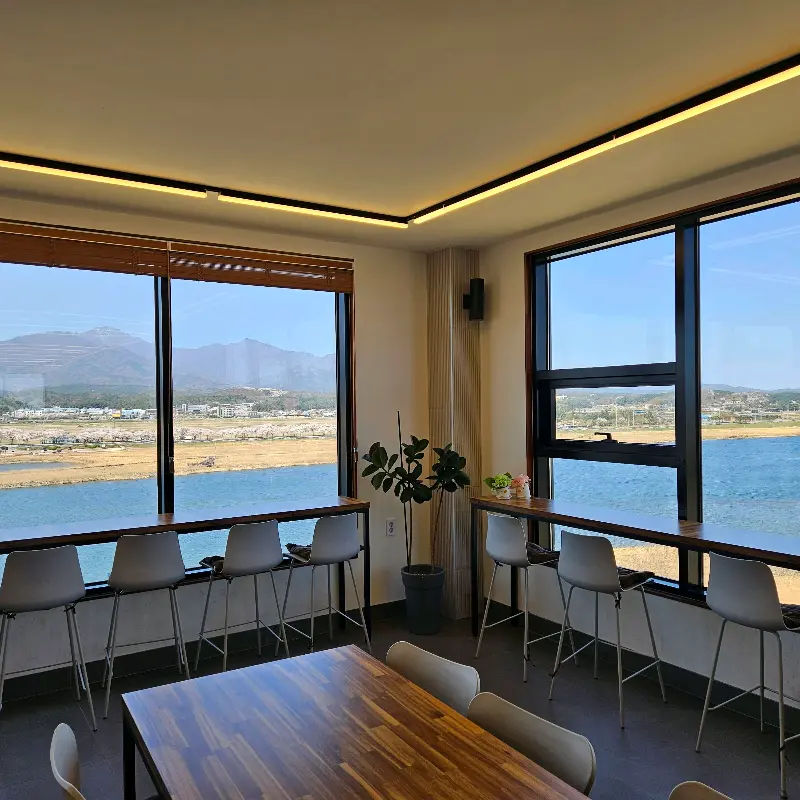 통창으로 시원한 뷰를 감상할 수 있는 카페 내부