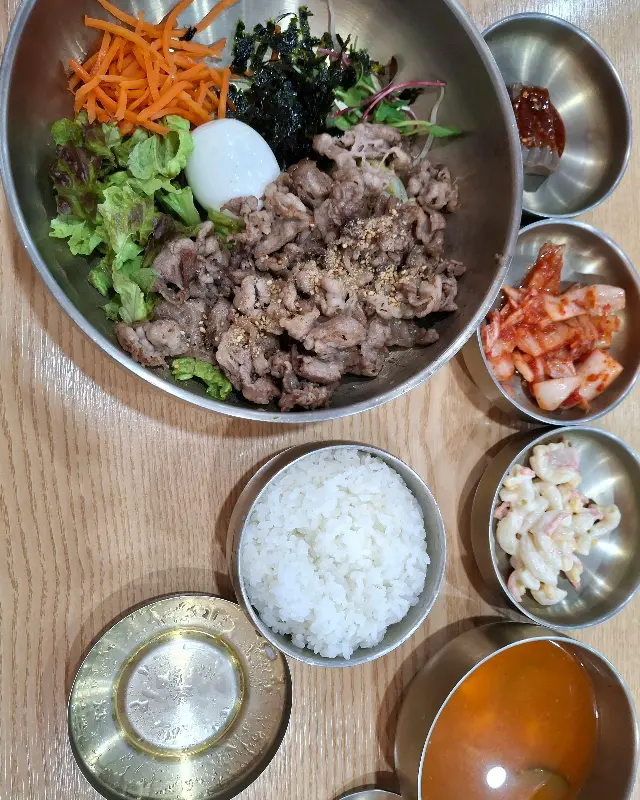 육회비빔밥에 계란이 얹혀 있는 모습