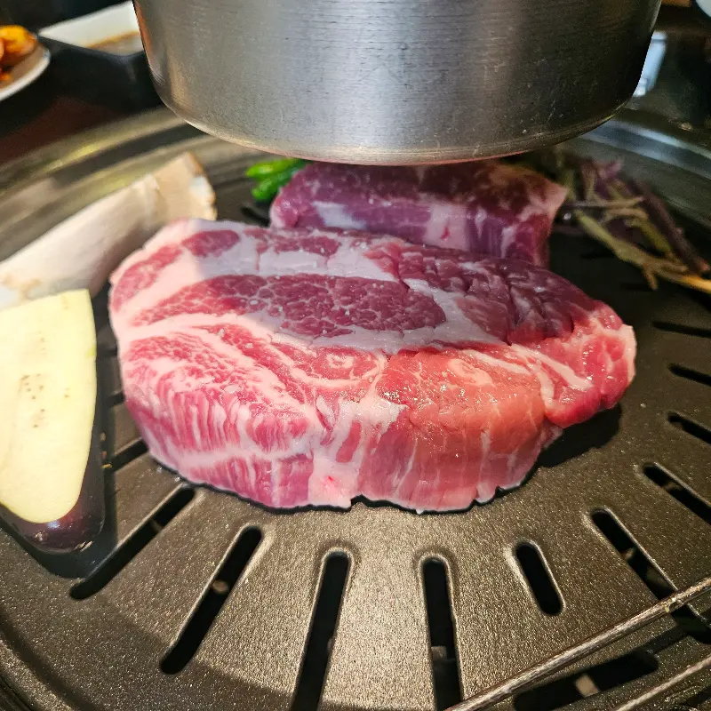 숯불 위에서 익어가는 두툼한 목살