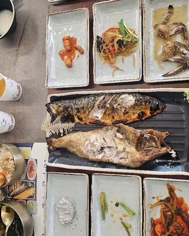 노릇하게 구워진 고등어와 다양한 밑반찬