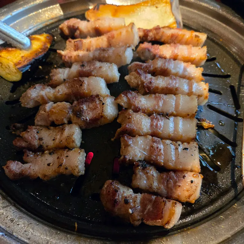 불판 위에서 노릇하게 구워지는 삼겹살