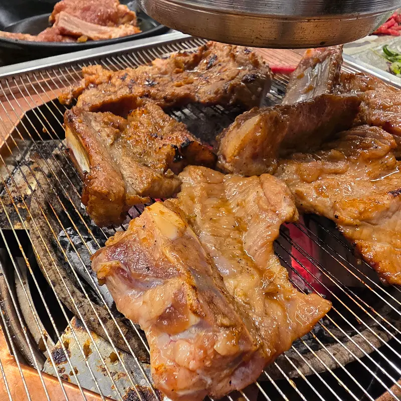 숯불 위에서 노릇노릇하게 익어가는 양념갈비