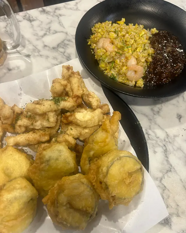 반반 튀김과 새우볶음밥이 함께 놓여 있는 테이블 사진. 튀김은 황금빛을 띠고 있으며, 볶음밥은 윤기가 흐른다.