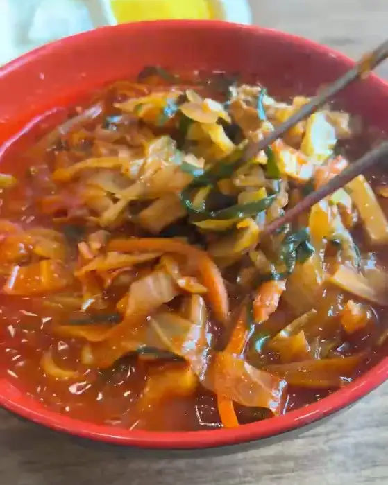 빨간 짬뽕 국물 안에서 젓가락으로 건져 올리는 면발과 각종 채소