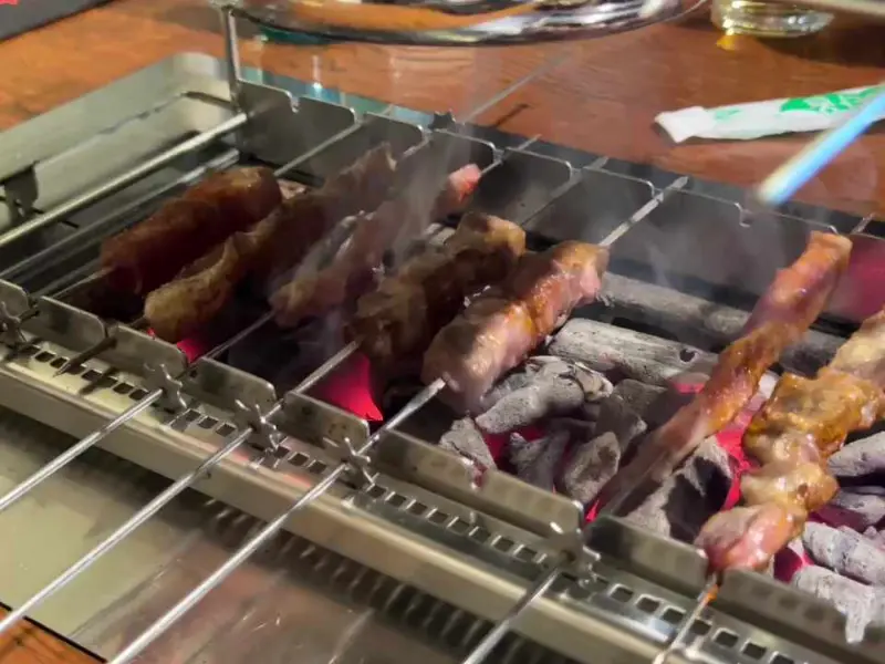 숯불 위에서 연기를 내뿜으며 익어가는 양꼬치