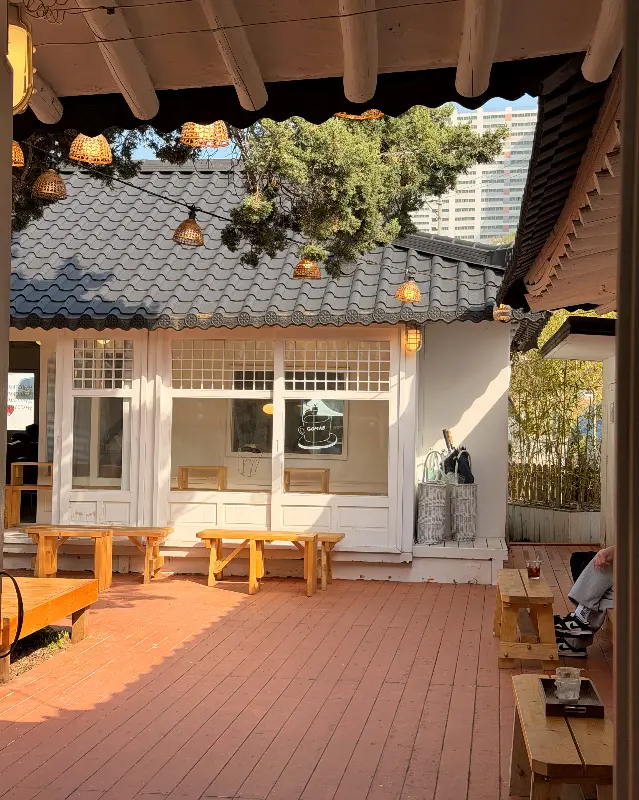 카페 외부 테라스의 모습. 나무 테이블과 의자가 놓여 있어 편안하게 휴식을 취할 수 있다.