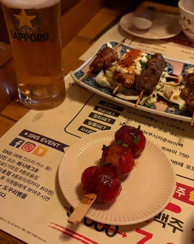 테이블 위에 놓인 꼬치와 맥주