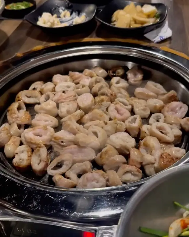 불판 위에서 노릇하게 구워지고 있는 막창의 모습