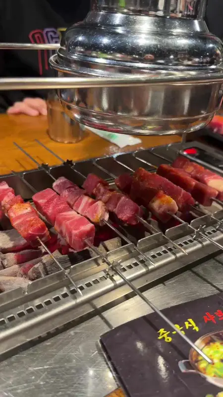 숯불 위에 가지런히 놓인 양꼬치