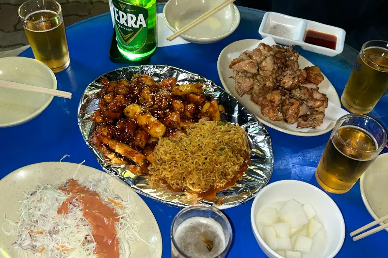테이블 가득 차려진 숯불 양념 순살 치킨, 소금구이, 맥주
