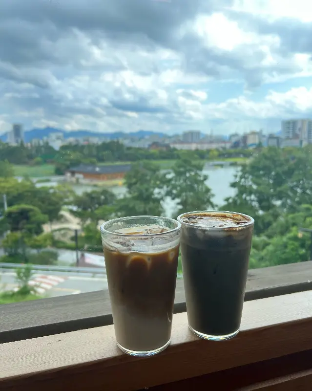 카페 한올에서 판매하는 음료 사진. 탁 트인 덕진공원 뷰가 보인다.
