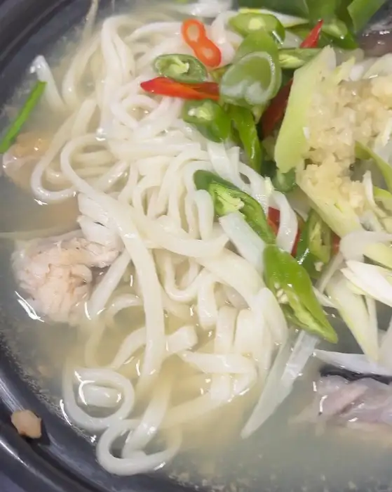 아귀수육 국물에 끓여진 칼국수 면과 고추, 파