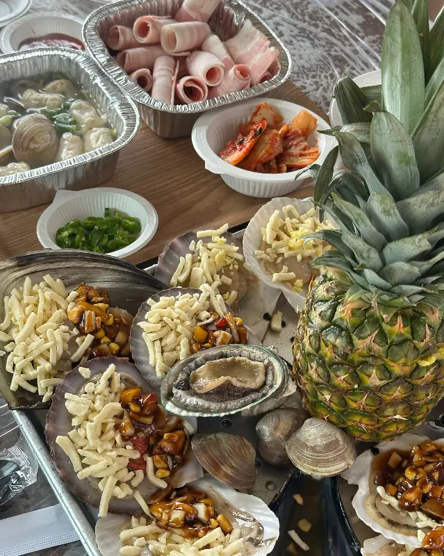 푸짐한 조개구이 한 상 차림. 신선한 해산물과 먹음직스러운 토핑이 시선을 사로잡는다.