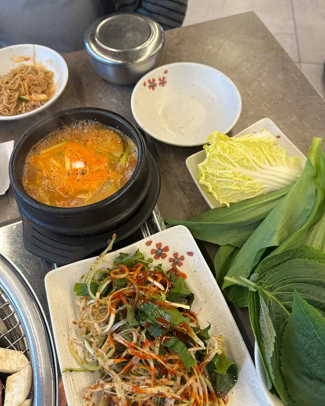 된장찌개, 샐러드, 쌈채소 등 푸짐하게 차려진 밑반찬