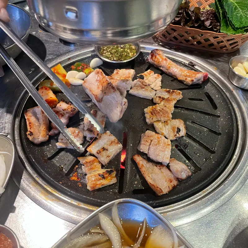 불판 위의 돼지갈비와 김치, 마늘