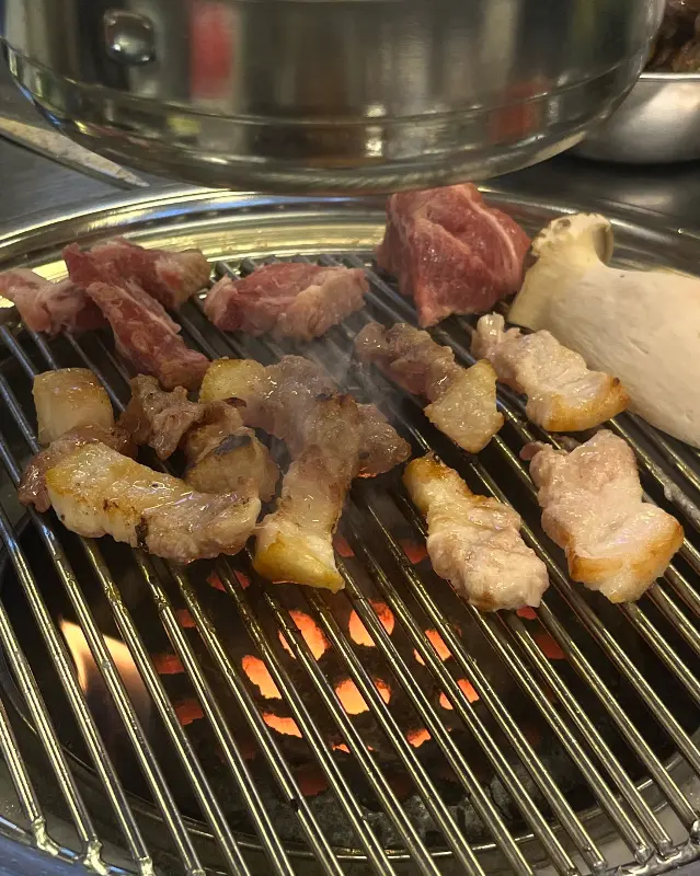 연탄불 위에서 구워지는 두툼한 돼지고기