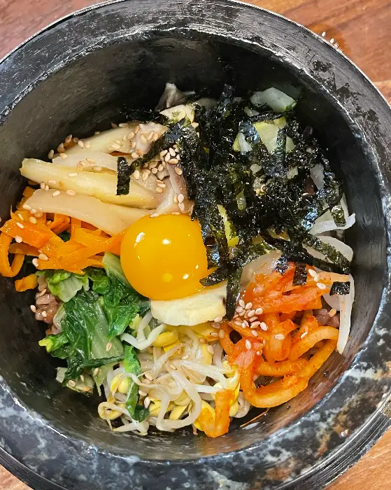 파전 위로 녹색 채소와 붉은색 토마토가 조화를 이룹니다.