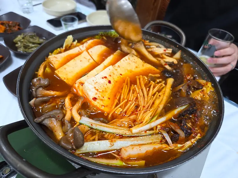 국자로 황태두부전골을 뜨는 모습