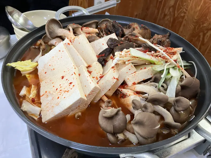 황태두부전골에 두부와 버섯, 채소가 가득한 모습