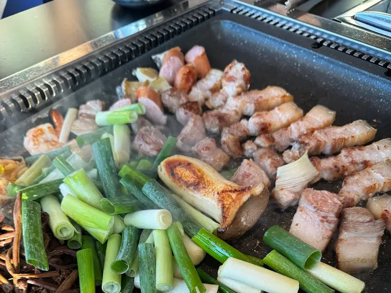 흑돼지 오겹살과 고사리가 함께 구워지는 모습