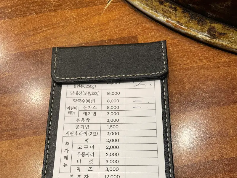 메뉴판 사진. 닭갈비 가격은 1인분에 16,000원이며, 막국수, 볶음밥, 우동사리 등 다양한 메뉴가 준비되어 있다.