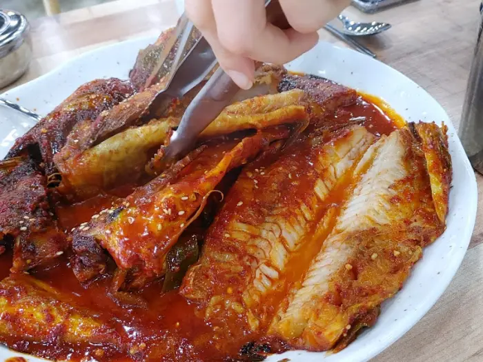 집게로 코다리 살점을 집고 있는 모습