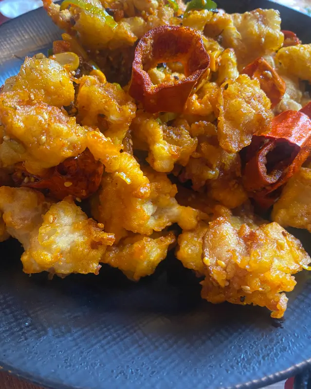 매콤해 보이는 고기 튀김 요리 사진. 붉은 고추가 Този вид го прави много съблазнителен.