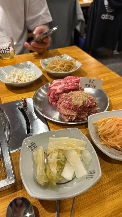 쌈 채소 위에 밥, 쌈장, 고기가 올라가 있습니다.