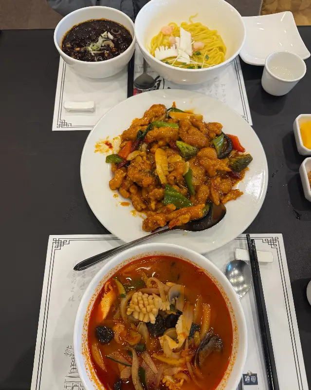 테이블 위에 가지런히 놓인 짜장면, 짬뽕, 탕수육