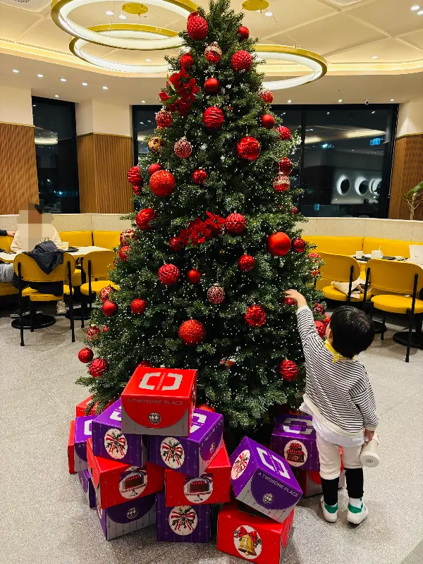 크리스마스 트리 장식 앞에서 사진을 찍는 아이