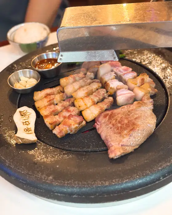 불판 위에서 노릇하게 익고 있는 삼겹살과 목살