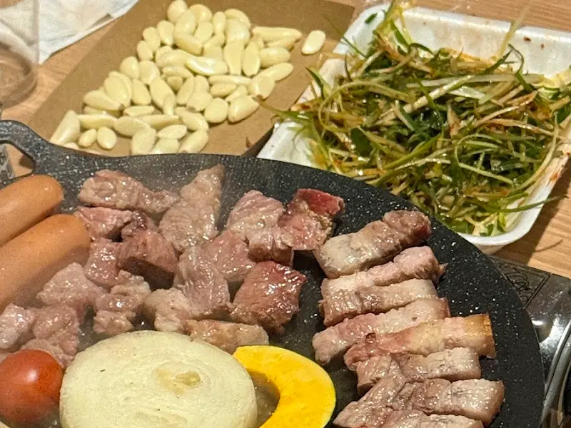 숯불 위에 구워지는 돼지고기와 소세지