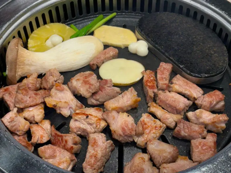 불판 위의 삼겹살과 다양한 구이 재료