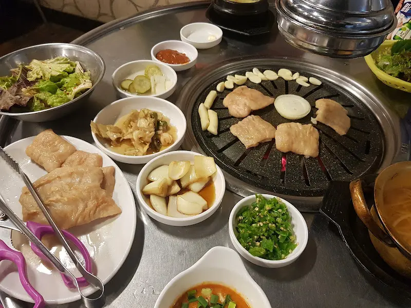 잘 구워진 막창과 다양한 밑반찬이 테이블 위에 놓여 있는 모습