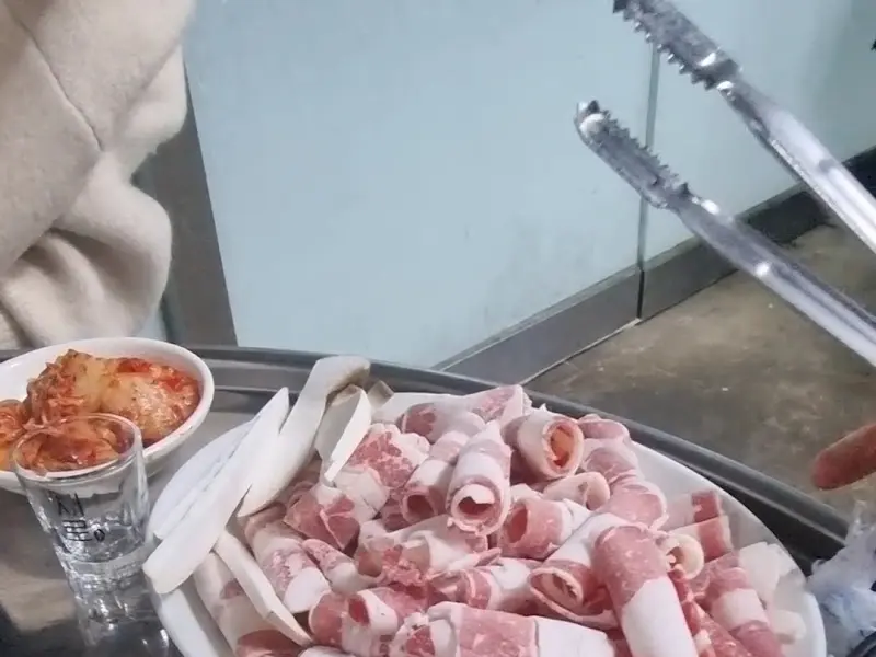 얇게 썰린 고기가 접시에 담겨 나오는 모습